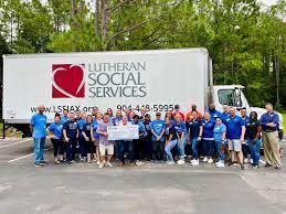 A group of people around a big truck that says Lutheran Social Services